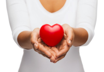 womans cupped hands showing red heart