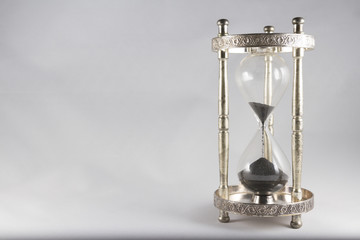 Hourglass – old fashioned hourglass, black sand, almost empty,