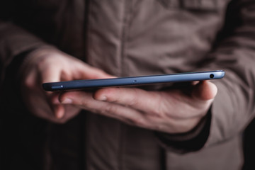 The man uses a tablet PC. Modern gadget in hand.