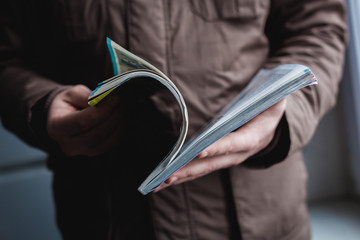 A man looks at a magazine. Press hands.