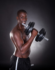 Fototapeta na wymiar Young African Man Exercising With Dumbbells