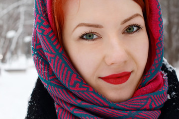 Pretty happy girl in red kerchief looks at camera outdoor