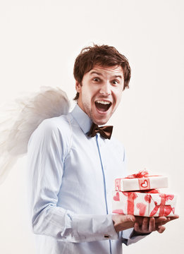 Handsome Young Man As Cupid Angel With Presents