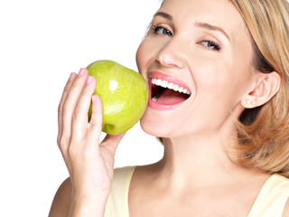 Beautiful young woman biting the biting a fresh ripe apple