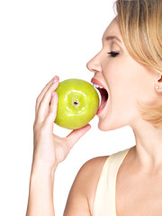 Beautiful young woman biting the biting a fresh ripe apple