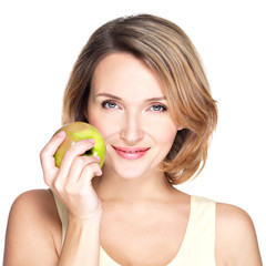 Young beautiful smiling woman touches the apple to face.