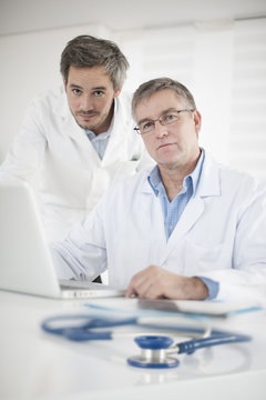 Clinical Director and his assistant discussing around a computer