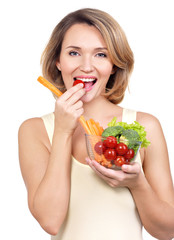 Beautiful young healthy woman eating a salad.