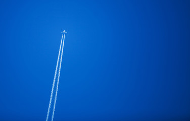 A high altitude plane flying across the biue sky background