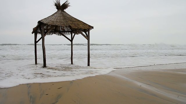 Shelter on the beach and big waves