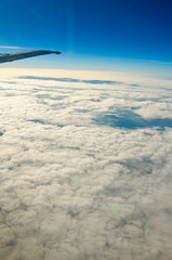Naklejka na ściany i meble View above clouds from window with airplane