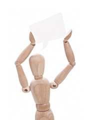 Wooden doll holds paper speech bubble