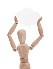 Wooden doll holds paper speech bubble