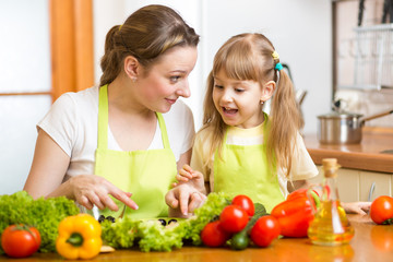 Young mother and her kid making vegetable salad
