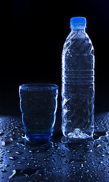 glass and bottle on freshness drinking water on wet floor with c