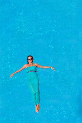 Woman floating above pool water