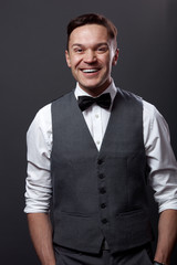 Handsome young man staying against gray wall