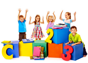 Children sitting at cube.