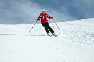 Skier in mountains against blue sky