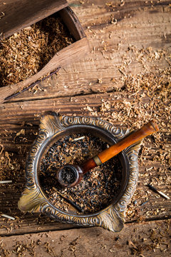 Wooden pipe with tobacco in an ashtray