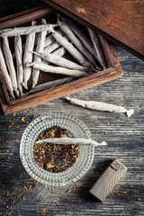 Fototapeta na wymiar Cigarettes in wooden box, ashtray and lighter