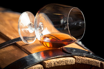 Glass of cognac on the old barrel