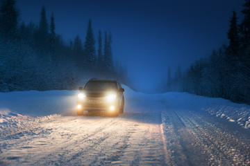 Car lights in winter Russian forest