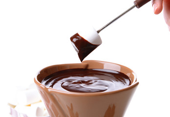 Chocolate fondue with marshmallow candies, isolated on white