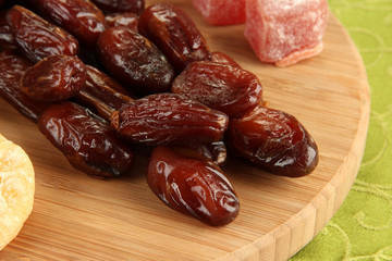 Dried dates with sweets on table close up