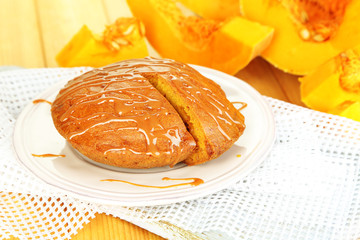 Delicious pumpkin pie on plate on wooden table close-up