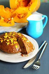 Delicious pumpkin pie on plate on wooden table close-up