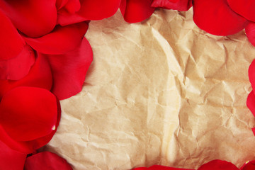Frame of rose petals on vintage paper background close-up