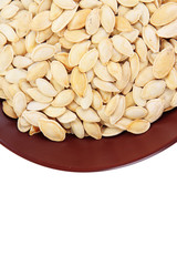 Pumpkin seeds in bowl isolated on white