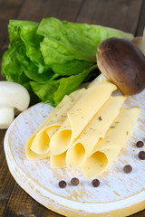 Cream cheese with vegetables and greens on wooden board