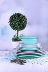 Clean dishes with flower on wooden table on natural background