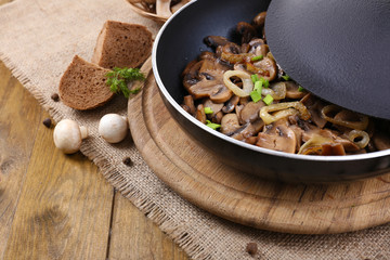 Delicious fried mushrooms in pan on table close-up