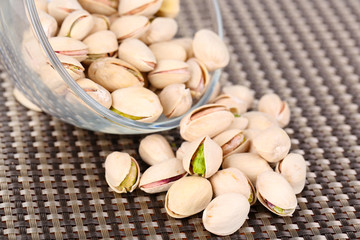 Pistachio nuts in glass bowl on table close up