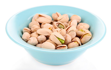 Pistachio nuts in bowl isolated on white