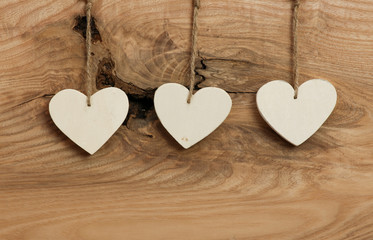 White Love Valentine's hearts hanging on wooden texture backgrou