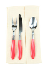 Kitchen cutlery on color napkin isolated on white
