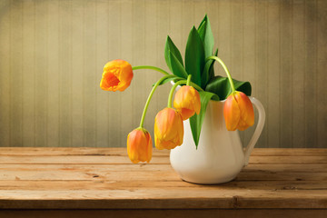 Tulip flowers in vase over vintage background