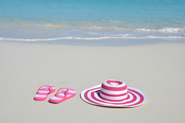 Fototapeta na wymiar Flip-flops and hat on the beach
