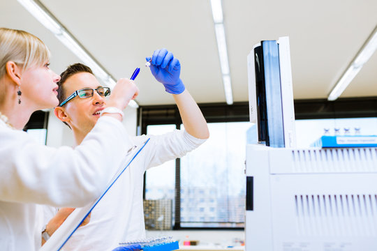 Two young researchers carrying out experiments in a lab