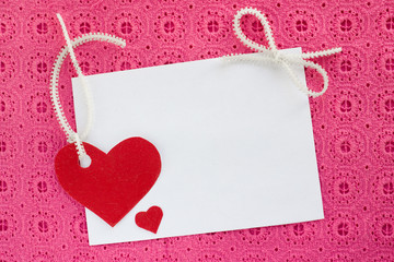 A blank white note card on pink background