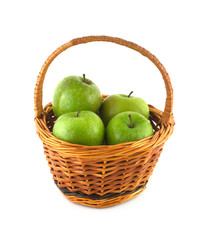 Ripe green apples in brown wicker basket isolated closeup