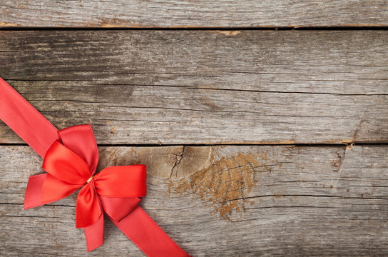 Wooden background with red bow and ribbon