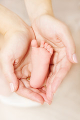 Obraz na płótnie Canvas Newborn baby foot parent holding in hands
