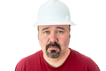 Morose glum looking man in a hardhat