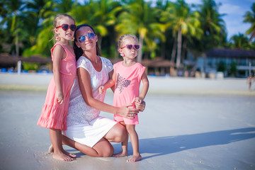 Fototapeta na wymiar Mother and her cute little girls relaxing on exotic tropical