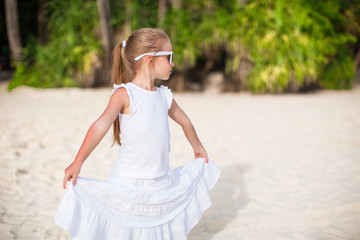 Portrait little adorable girl in white long dress on a tropical